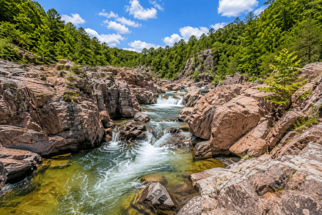 Johnson's Shut-Ins State Park in Missouri featuring natural rock chutes, pink granite formations, and clear rushing water flowing through the Ozark Mountains.